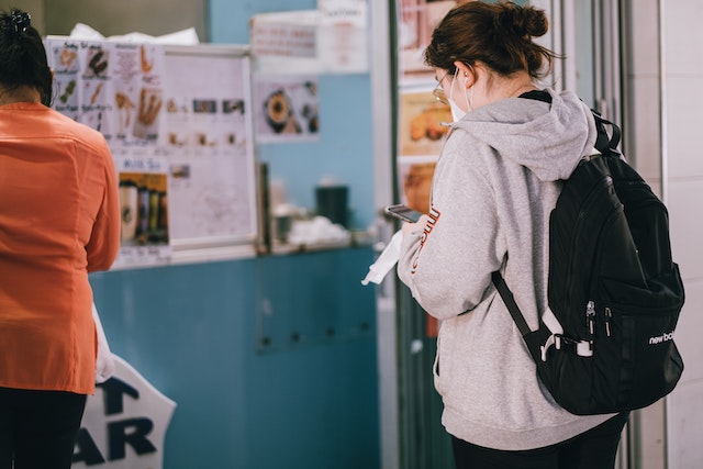 woman-in-gray-hoodie-standing-waiting-in-line-